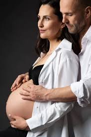 Caucasian husband hugging his pregnant wife